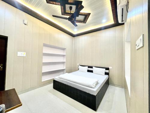 sypialnia z łóżkiem i wentylatorem sufitowym w obiekcie Hotel DEV VILLA GUEST HOUSE ! VARANASI fully-Air-Conditioned hotel at prime location, near Kashi Vishwanath Temple, and Ganga ghat w mieście Waranasi