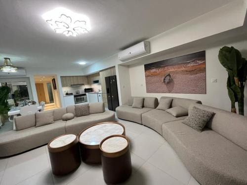 uma sala de estar com dois sofás e duas mesas em Marassi Marina Chalet em El Alamein