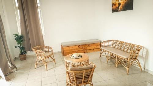 a room with chairs and a bench and a table at Les Manglier in Port Mathurin