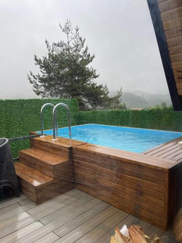 uma piscina com um deque de madeira e uma banheira de hidromassagem em Perla em Hendek