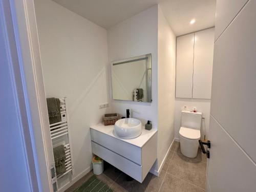 a white bathroom with a sink and a toilet at Joli duplex, coeur du Pouliguen in Le Pouliguen