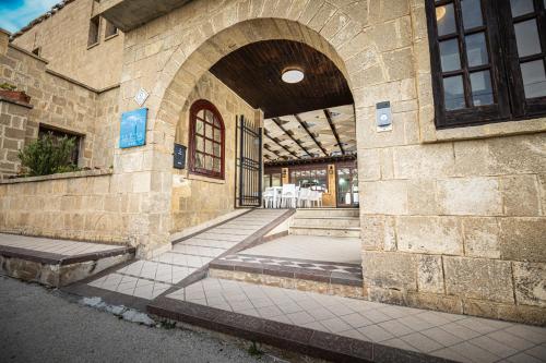 um edifício de pedra com um arco na lateral em La Rosa Hotel - Selinunte em Marinella di Selinunte
