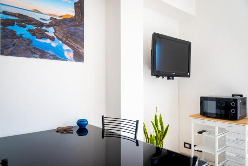 una camera con tavolo e TV a parete di Appartamento Il Mare e Dintorni a Portoferraio