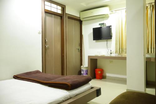 a room with a bed and a flat screen tv at Hotel Neelkanth , Bhopal in Bhopal