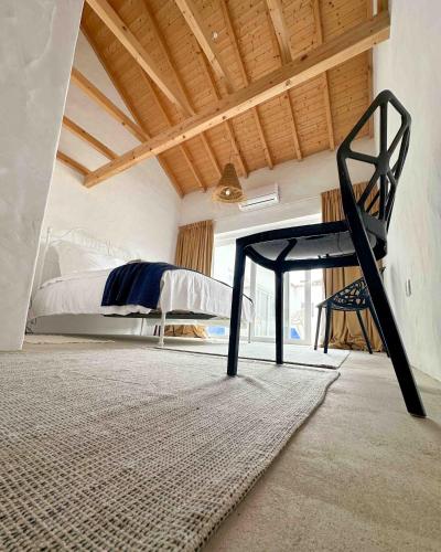 a bedroom with a bed and a chair in it at Valle D`Água - Casas de campo in Vale de Água