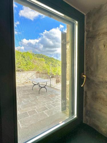 a window with a view of a bench on a patio at Waterfall Kataraktis Vatatsi in Vatátsion