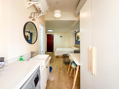 une salle de bains avec lavabo et une chambre avec 2 lits dans l'établissement 深圳LaCave公寓, à Shenzhen