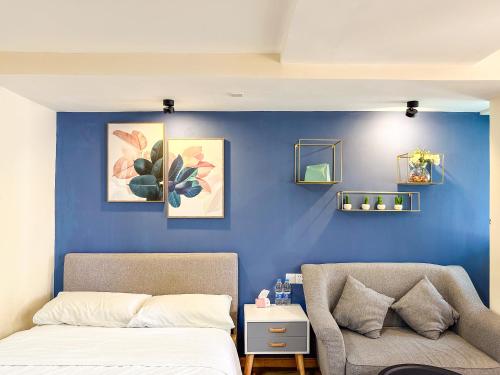 - une chambre dotée d'un mur bleu avec un lit et une chaise dans l'établissement 深圳LaCave公寓, à Shenzhen