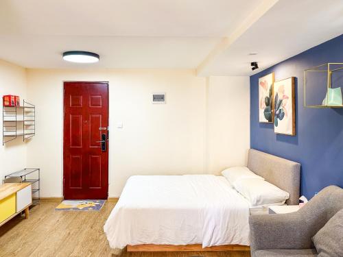 a bedroom with a bed and a couch and a red door at 深圳LaCave公寓 in Shenzhen