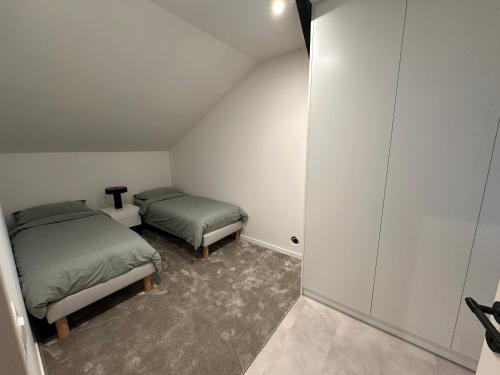 a attic room with two beds in a room at Charmant duplex au Pouliguen in Le Pouliguen