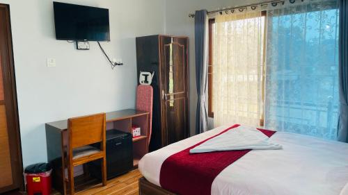 1 dormitorio con 1 cama, TV y ventana en Typical Nepali Kitchen - No Pizza - No Pasta - No Problem !! en Sauraha