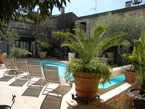 - un groupe de chaises et une piscine avec des plantes dans l'établissement Le Castélas, à Aiguèze
