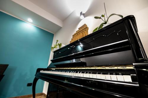 a black piano in a room with a plant at La Rosa Hotel - Selinunte in Marinella di Selinunte