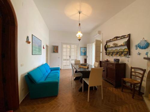 a living room with a blue chair and a table at Villa Marina con 10 posti letto a 350 mt dal mare in Campomarino