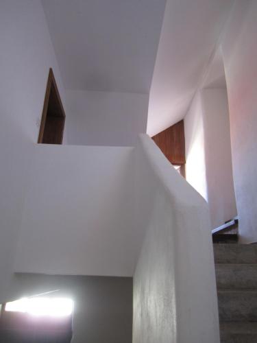 a staircase in a house with white walls and wooden ceilings at Holubník statečných žen králových in Luže