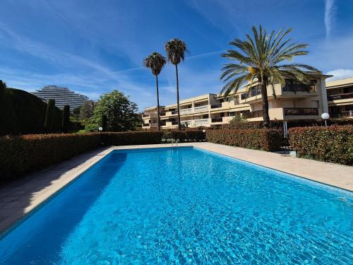 une piscine bleue en face d'un bâtiment dans l'établissement Superbe T2 - 200m de la mer - Piscine - Parking, à Villeneuve-Loubet
