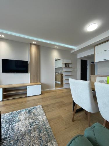 a living room with a television and a table and chairs at Relax Residence in Golubac