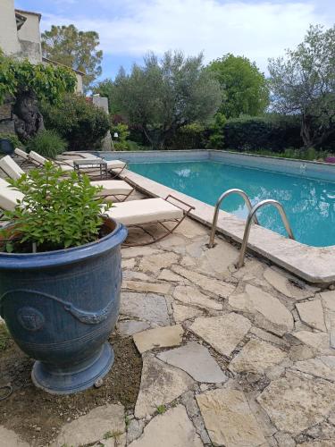 Una maceta azul con una planta al lado de una piscina. en B&B Chambre indépendante double, en Deaux