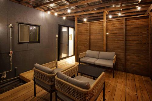 a room with a couch and a chair and a table at 日向サーフキャンプ110 in Hyuga
