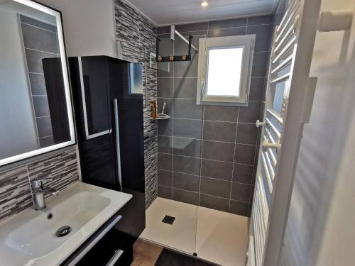 een badkamer met een wastafel en een douche bij Entre mer et foret 1 in Jard-sur-Mer