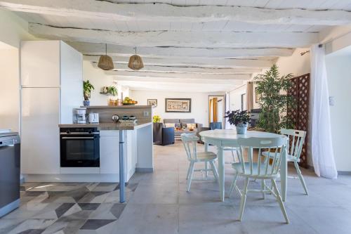 une cuisine et une salle à manger avec une table et des chaises dans l'établissement les coteaux de Proumeyssac, à Audrix
