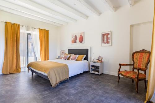 une chambre avec un lit et une chaise dans l'établissement les coteaux de Proumeyssac, à Audrix