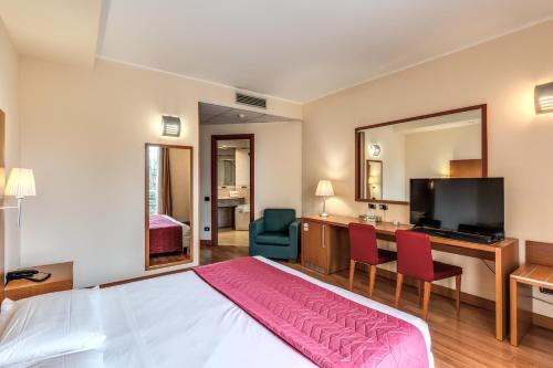 a hotel room with a bed and a large mirror at Luna Hotel Lago Maggiore Arona in Oleggio Castello