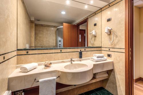 a bathroom with a sink and a mirror at Luna Hotel Lago Maggiore Arona in Oleggio Castello