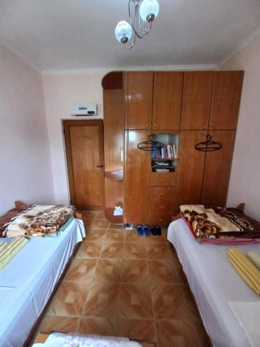 two beds in a room with wooden cabinets at MiziriGuestHouse in Gjirokastër