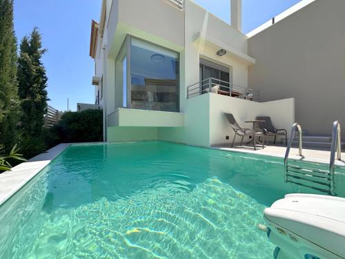 a swimming pool in front of a house at RVG Jenny House with pool in Porto Heli