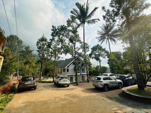 a house with cars parked in a parking lot at Wild Brooke Guest House in Vythiri