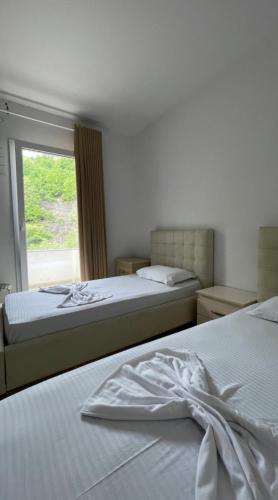 1 dormitorio con 2 camas y ventana en Hotel Skura, en Librazhet