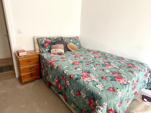 um quarto com uma cama com um edredão verde e uma mesa de cabeceira em Spacious Relaxing Double Bedroom near Heart of City em Birmingham