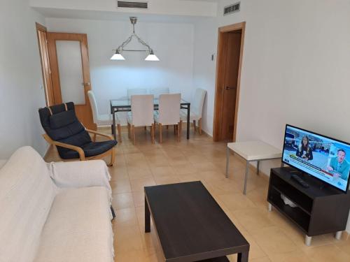 a living room with a couch and a table at Apartamentos Punta Cormorán V.v. in La Manga del Mar Menor