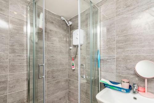 a bathroom with a shower and a sink at A Cosy Deluxe Size Studio With Queen size and Sofa Bed in Leeds