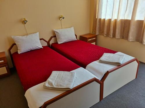 two beds in a room with red and white at Доли in Pomorie