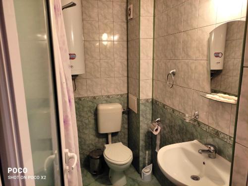 a small bathroom with a toilet and a sink at Доли in Pomorie