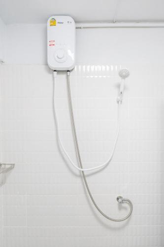 a shower with a hose attached to a wall in a bathroom at Chummy House Khaosan 10-Min, Peace Haven in Bangkok