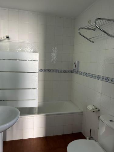 a bathroom with a tub and a sink and a toilet at Apartamentos La Peral in La Peral