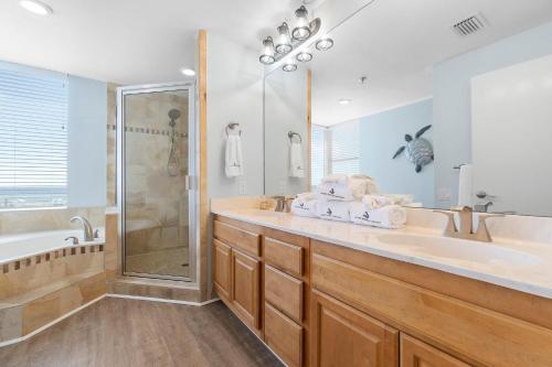 a bathroom with a tub and a sink and a shower at Beach Colony West 1B in Perdido Key
