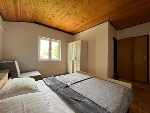 a bedroom with a large bed with a wooden ceiling at Apartments Babić in Rab