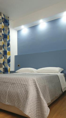 a bedroom with a bed with a blue wall at Il Giramondo in Aversa