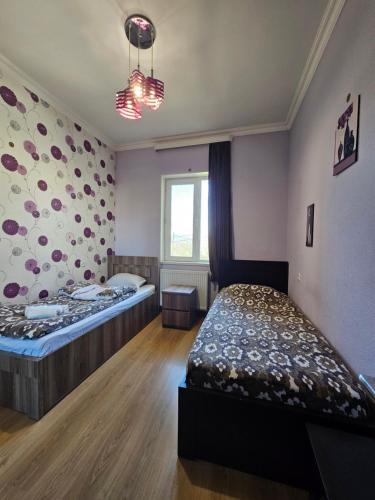 a bedroom with two beds and a window at Guesthouse different in Tbilisi City