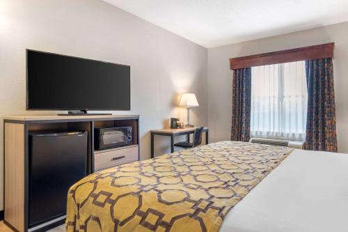 a hotel room with a bed and a flat screen tv at Baymont by Wyndham Kennesaw in Kennesaw