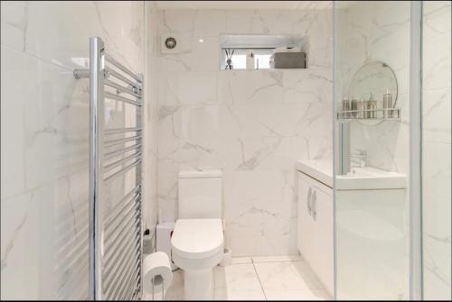 a white bathroom with a toilet and a sink at SLS VACATION STAY in Kent