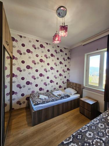 a bedroom with a bed and a flower wall at Guesthouse different in Tbilisi City