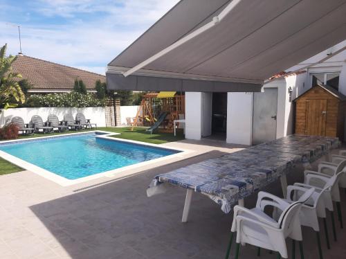 un patio con una mesa y una piscina en Villa Cambrils Mar, en Cambrils