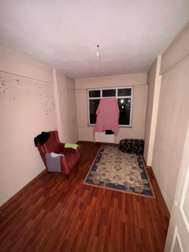 ein Wohnzimmer mit einem roten Stuhl und einem Fenster in der Unterkunft Beyazıt Suit in Sarıgazi