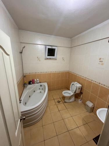 ein Badezimmer mit einer Badewanne, einem WC und einem Waschbecken in der Unterkunft Beyazıt Suit in Sarıgazi