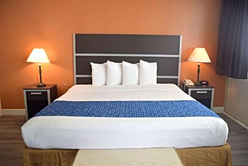 a large bed in a hotel room with two lamps at Travelodge by Wyndham San Francisco Airport North in South San Francisco